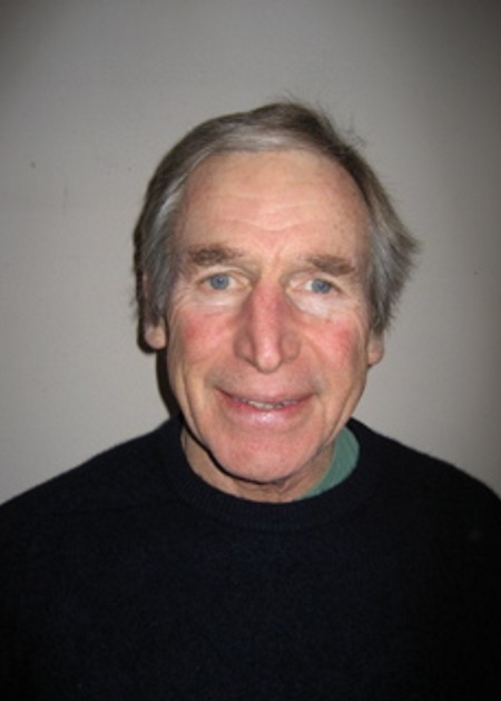 A man with grey hair and wearing a black shirt.