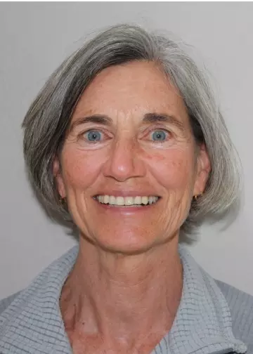 A woman with grey hair smiling for the camera.